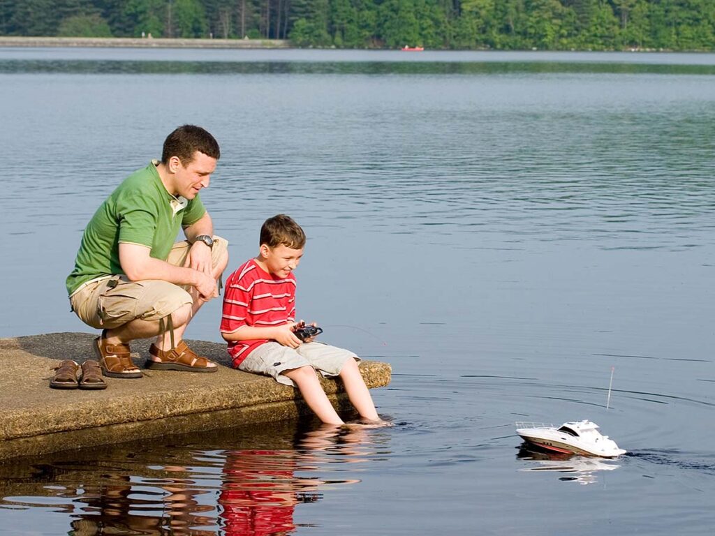 Father and son playing with a remote controlled boat.